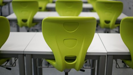 Das Foto zur Pressemitteilung der Linken NRW zu Schulöffnungen zeigt einen Stuhl in einem Klassenraum, der auf den Tisch gestellt worden ist. 