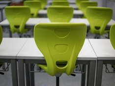 Das Foto zur Pressemitteilung der Linken NRW zu Schulöffnungen zeigt einen Stuhl in einem Klassenraum, der auf den Tisch gestellt worden ist. 