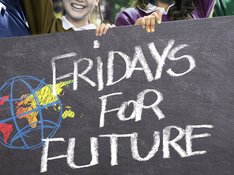 Auf dem Foto halten vier Kinder ein Plakat mit der Aufschrift Friday's for Future