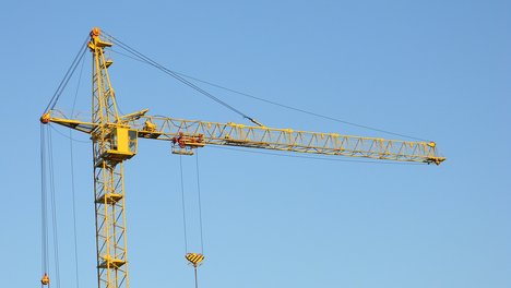 Sozialwohnungen DIE LINKE Amid Rabieh Das Bild zeigt einen mehrstöckigen Rohbau und dazu einen gelben Baukran.
