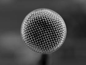 Das Bild zeigt eine Schwarz-Weiß-Aufnahme eines Mikrofons. 