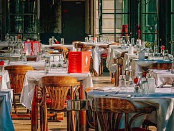 Das Foto zur Pressemitteilung der Linken NRW zu den Folgen der Corona-Pandemie für Gastronomie und Kulturschaffende zeigt ein leeres Restaurant mit gedeckten Tischen