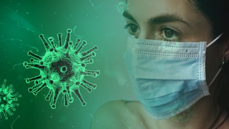 Das BAG W fordert Schutzmaßnahmen für Wohnungslose zeigt eine Bild des Virus sowie angeschnitten das Profil einer Frau mit Mundschutz. 