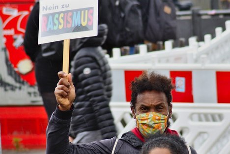 Das Foto zeigt Menschen auf einer Demo, die gegen Rassismus protestieren..