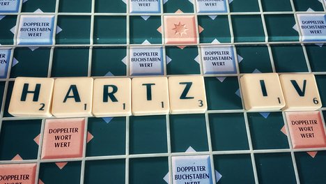 Das Foto zur Pressemitteilung zu den Erwerbslosenzahlen zeigt Buchstaben-Spielsteine, die das Wort Hartz IV bilden. 