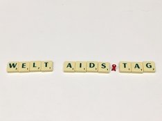 Das Foto zeigt Scrabble-Buchstabem, die so angeordnet sind, dass sie das Wort Welt-AIDS-Tag ergeben.