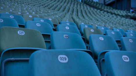 Das Foto zeigt eine Stuhlreihe in einem Stadion. 