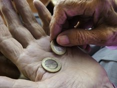 Das Foto zur Pressemitteilung der Linken NRW zum Abschlussbericht der Rentenkommission zeigt die Hände einer älteren Person. Auf der Innenfläche der einen Hand liegen zwei Euro. 