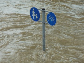 Das Foto zeigt ein Straßenschild bei Hochwasser.