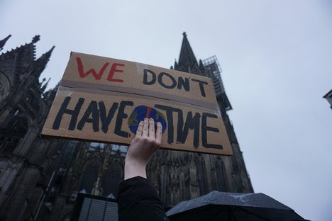 Das Foto zeigt ein Schild bei einer Klimademo vor dem Kölner Dom. Auf dem Schild steht: We don't have time