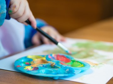 Tisch mit Kinderhand, die malt