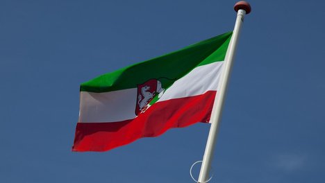 Das Foto zeigt eine wehende Fahne des Landes NRW
