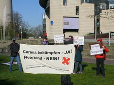 Das Foto zur Pressemitteilung zur Mahnwache gegen das Pandemie-Gesetz zeigt Teilnehmende der Mahnwache mit Transparenten vor dem NRW-Landtag.