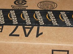 Das Foto zeigt den Ausschnitt eines Pakets mit einem Klebeband, auf dem Amazon steht. 