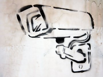 Das Foto zeigt das Graffito einer Überwachungskamera.